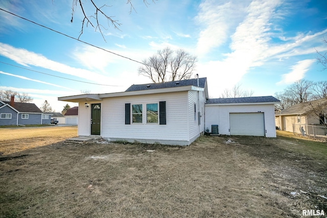 single story home with a garage, a front yard, central AC, and driveway