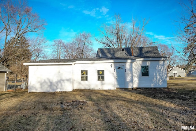 exterior space featuring roof with shingles and a yard