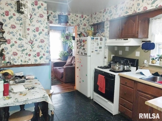 kitchen featuring wallpapered walls, white appliances, a healthy amount of sunlight, and under cabinet range hood