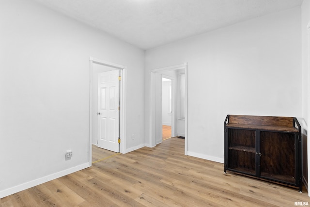 spare room with light wood-style floors and baseboards