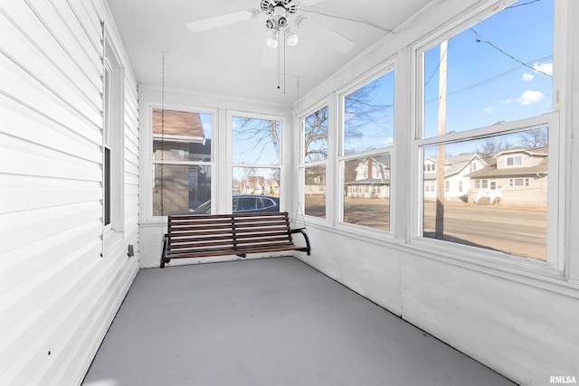 unfurnished sunroom featuring a ceiling fan