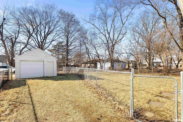 view of yard with an outbuilding, a detached garage, and fence