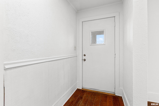 entryway featuring ornamental molding, dark wood-type flooring, and wainscoting