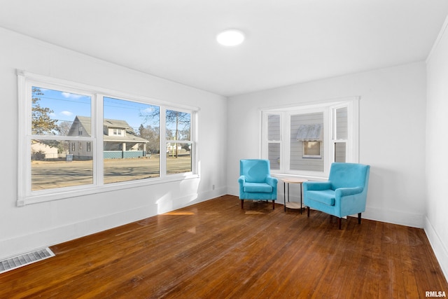 unfurnished room with hardwood / wood-style flooring, baseboards, and visible vents