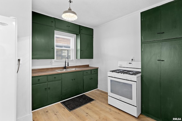 kitchen featuring green cabinets, light wood-style floors, ornamental molding, a sink, and white appliances