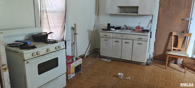 kitchen featuring light countertops, visible vents, white cabinetry, a sink, and white range with gas stovetop