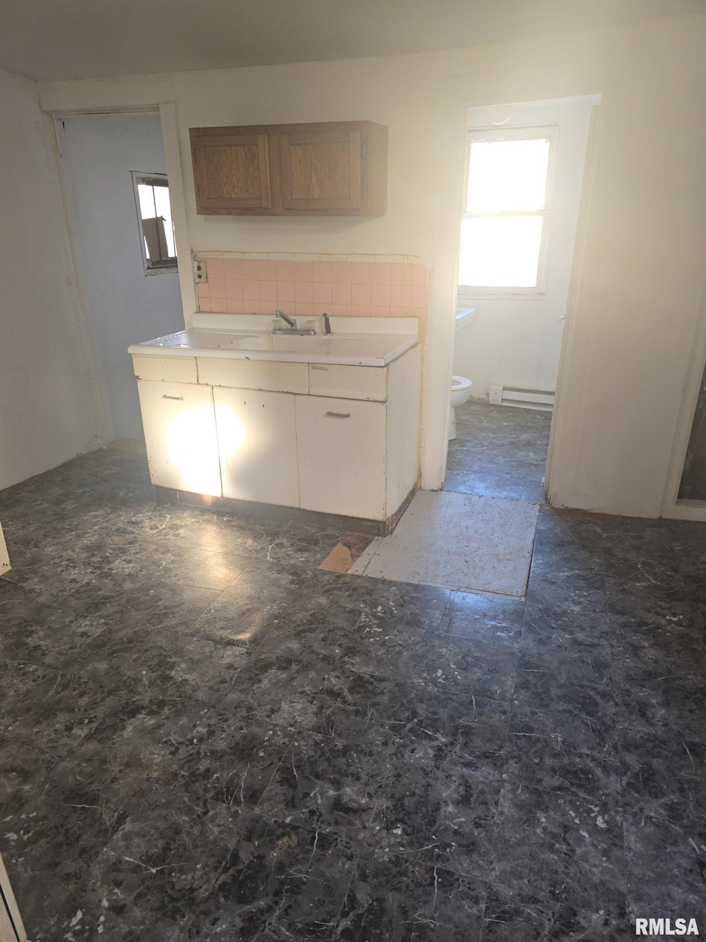 kitchen with backsplash and baseboard heating