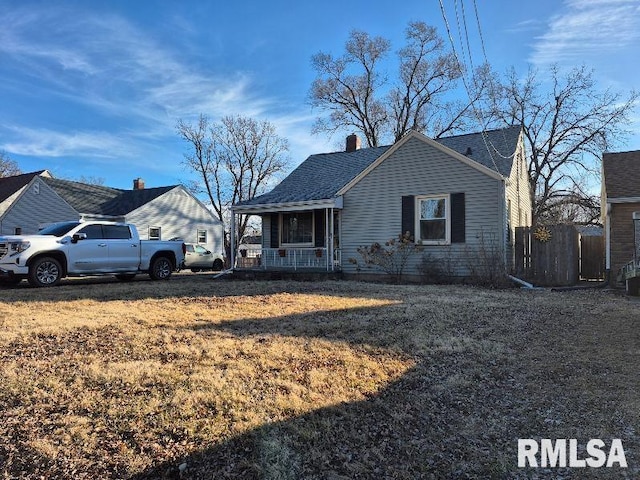 bungalow-style home with a porch, roof with shingles, fence, and a chimney