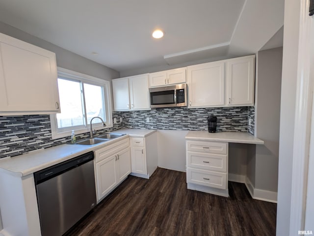 kitchen featuring white cabinets, appliances with stainless steel finishes, dark wood finished floors, and a sink