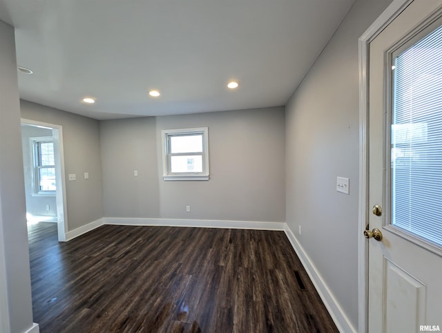 spare room with dark wood-type flooring, recessed lighting, and baseboards