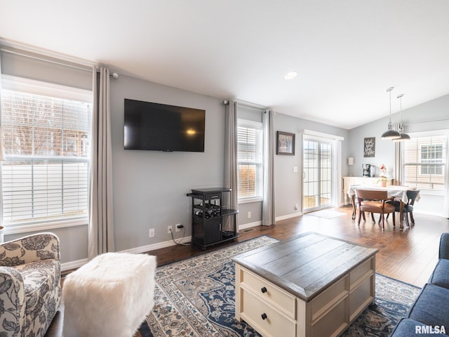 living room with dark wood-type flooring, lofted ceiling, and baseboards