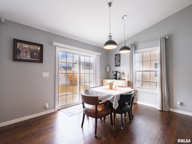 dining space featuring vaulted ceiling, dark wood-type flooring, and a healthy amount of sunlight