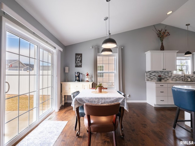 dining room featuring lofted ceiling, dark wood-style flooring, and plenty of natural light