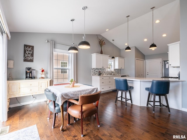 dining space with visible vents, vaulted ceiling, dark wood-type flooring, and recessed lighting