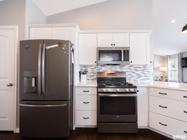 kitchen featuring appliances with stainless steel finishes, white cabinets, and vaulted ceiling