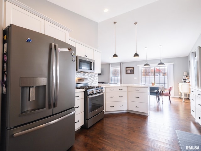 kitchen with a peninsula, appliances with stainless steel finishes, light countertops, and white cabinets