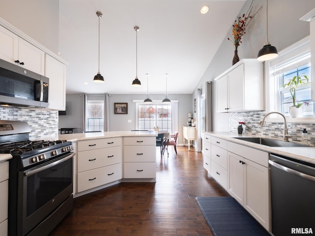 kitchen featuring a sink, white cabinetry, appliances with stainless steel finishes, backsplash, and dark wood-style floors