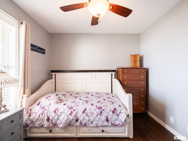 bedroom with a ceiling fan, baseboards, and dark wood-type flooring