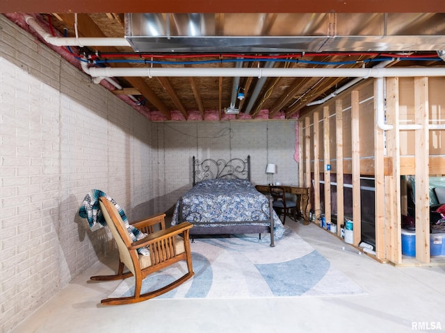 bedroom featuring concrete flooring and brick wall