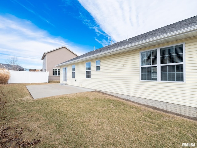 rear view of property with a patio, a lawn, and fence