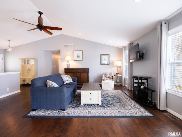 living room featuring lofted ceiling, visible vents, baseboards, and wood finished floors