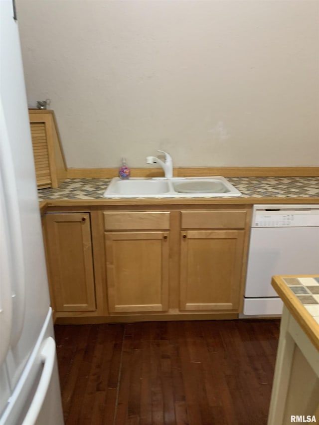 kitchen featuring white appliances, tile counters, dark wood-type flooring, and a sink