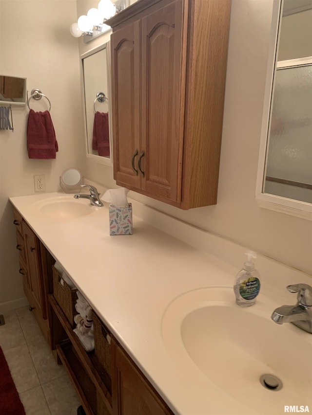 bathroom with double vanity, a notable chandelier, a sink, and tile patterned floors