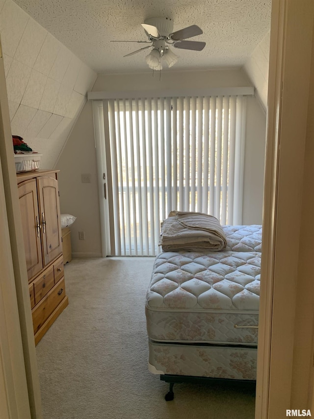 bedroom with vaulted ceiling, carpet floors, access to outside, and a textured ceiling