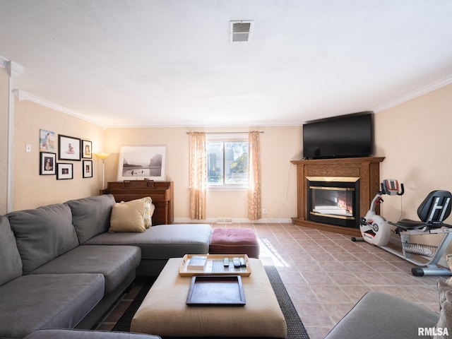 tiled living area with baseboards, a glass covered fireplace, visible vents, and crown molding