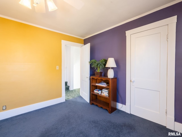 carpeted spare room with crown molding, baseboards, and ceiling fan