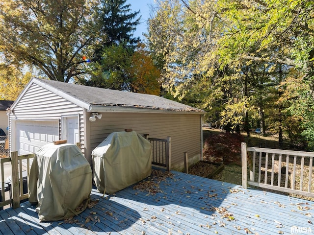 wooden deck with a garage, grilling area, and an outbuilding