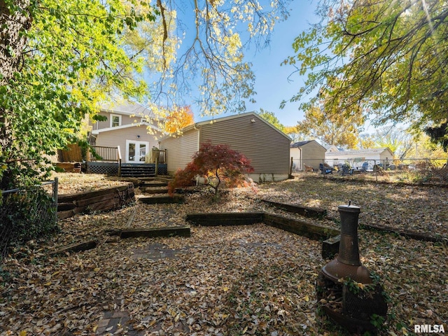 rear view of property with french doors, fence, and a wooden deck