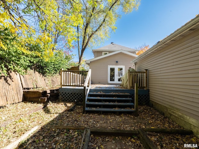 rear view of property featuring fence, french doors, and a wooden deck