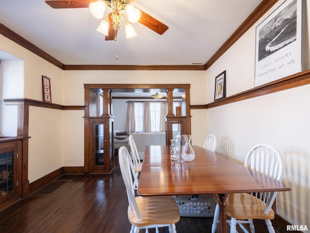 dining area with baseboards, wood finished floors, visible vents, and crown molding