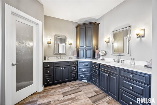 bathroom featuring double vanity, a sink, and wood finished floors