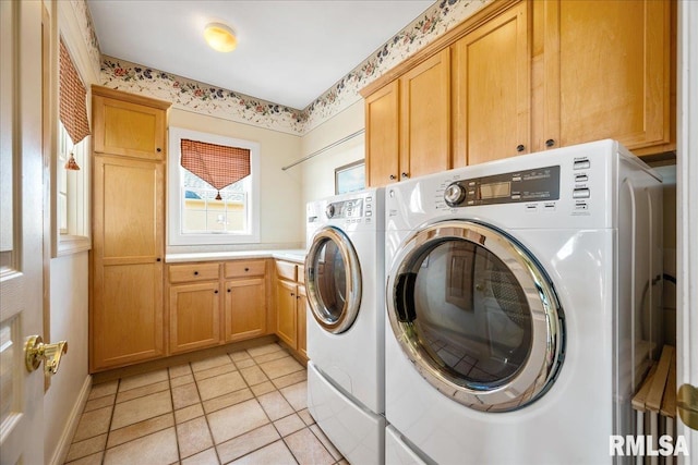 laundry area with cabinet space, light tile patterned floors, and washer and dryer