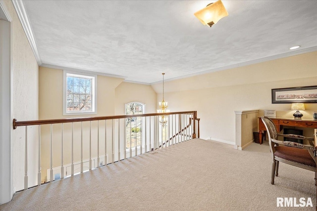 hallway featuring lofted ceiling, a notable chandelier, an upstairs landing, carpet, and crown molding