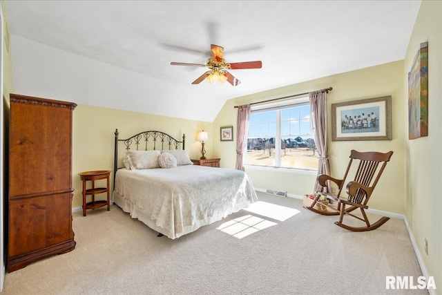 bedroom with baseboards, visible vents, a ceiling fan, light colored carpet, and lofted ceiling