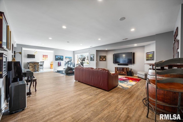 living room featuring baseboards, light wood-style flooring, and recessed lighting