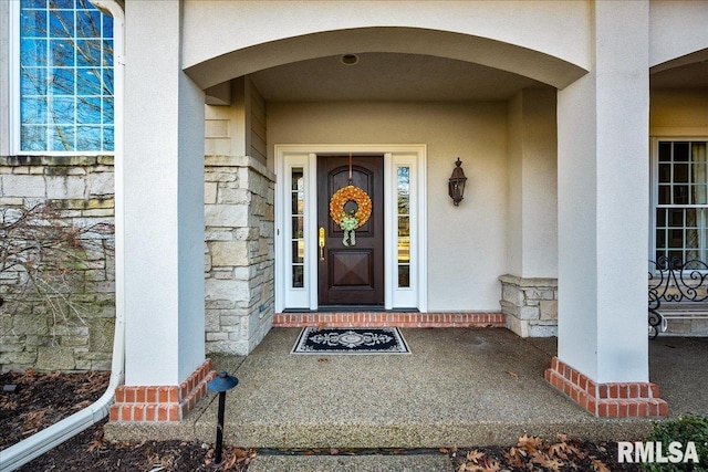 property entrance with stone siding and stucco siding