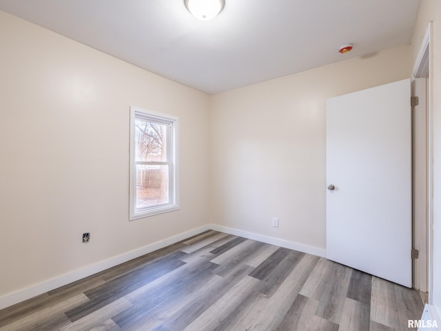 unfurnished room with baseboards and wood finished floors