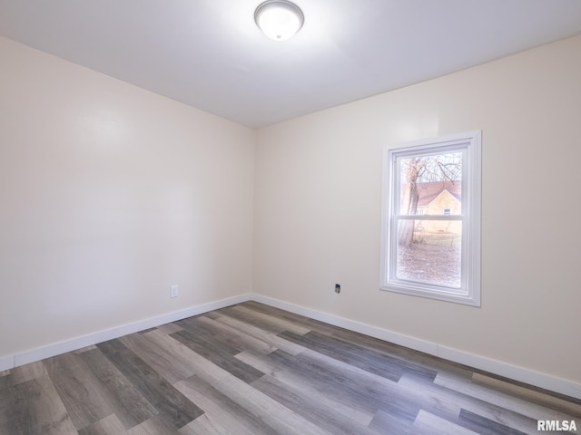 empty room featuring baseboards and wood finished floors