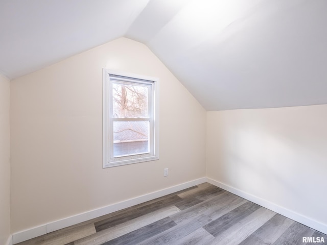 bonus room with lofted ceiling, baseboards, and wood finished floors