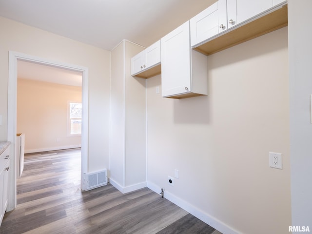 washroom featuring baseboards, visible vents, electric dryer hookup, and wood finished floors