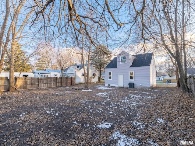 rear view of property featuring central air condition unit, fence, and roof with shingles