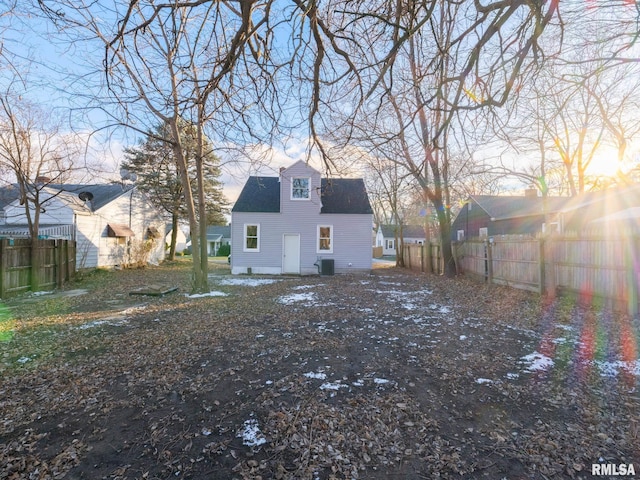 rear view of house with roof with shingles, cooling unit, and fence