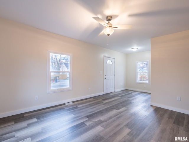 interior space with ceiling fan, dark wood-style flooring, visible vents, and baseboards