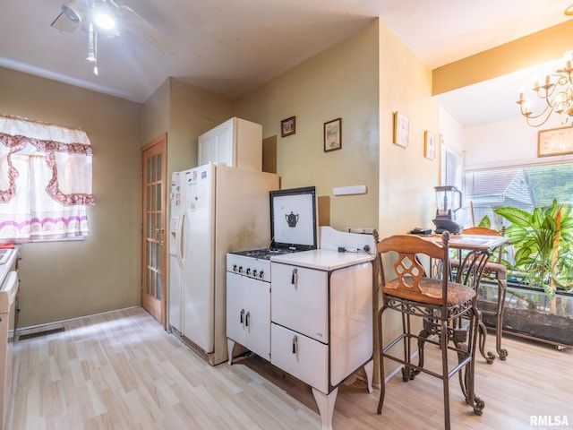 kitchen featuring a notable chandelier, white refrigerator with ice dispenser, visible vents, white cabinets, and light wood finished floors