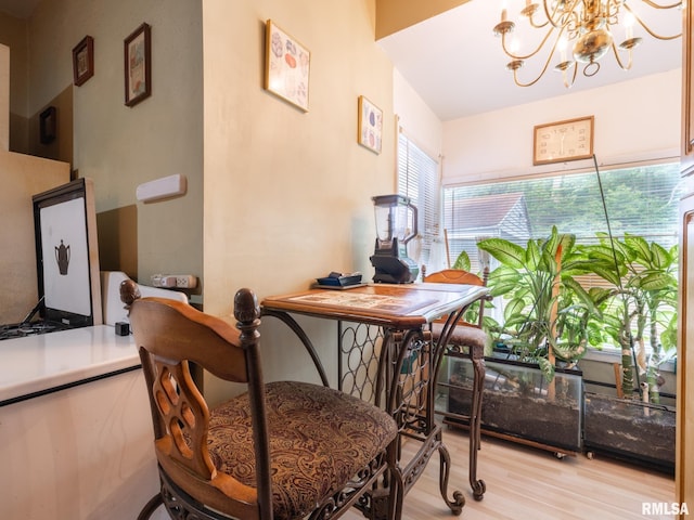 dining area with light wood-style floors and a notable chandelier