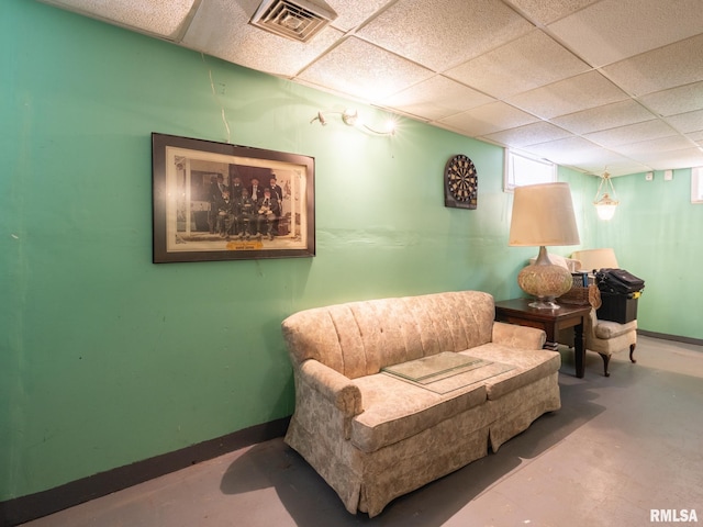 sitting room with baseboards, visible vents, and a drop ceiling